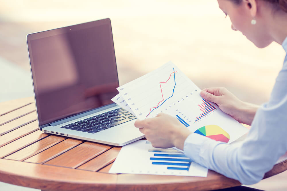 woman investment consultant analyzing company annual financial report balance sheet statement working with documents graphs. Stock market, office, tax, education concept. Hands with charts papers (1)